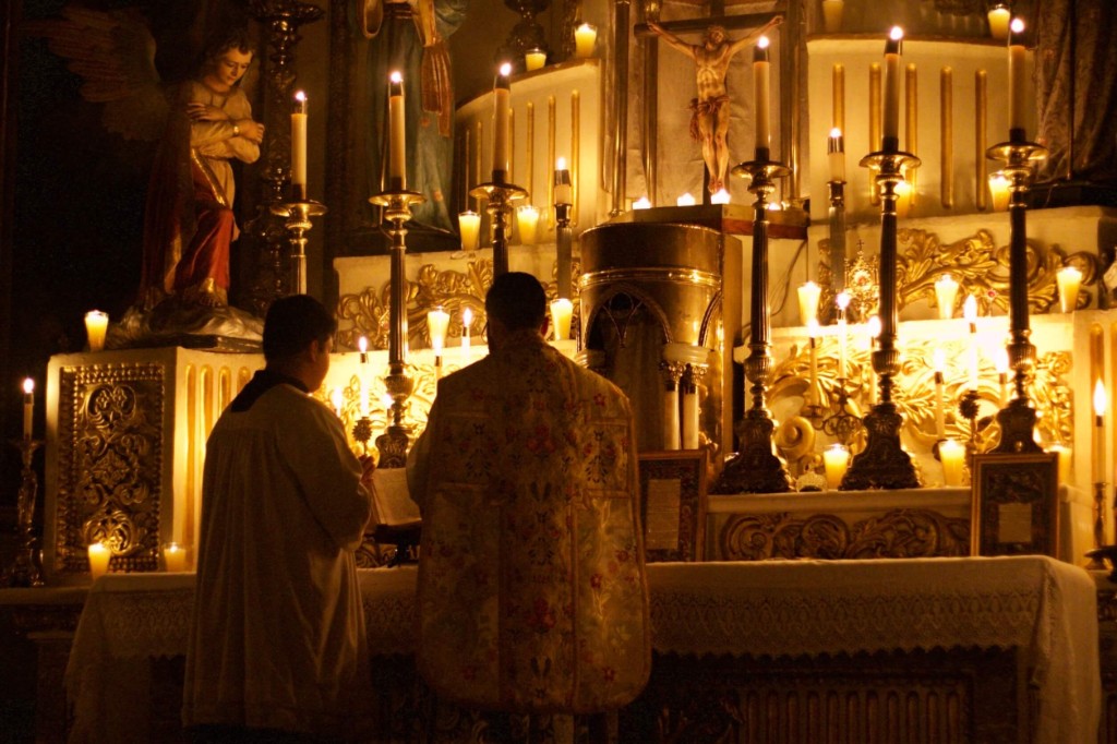 Altar tradicional iluminado por velas durante la Santa Misa